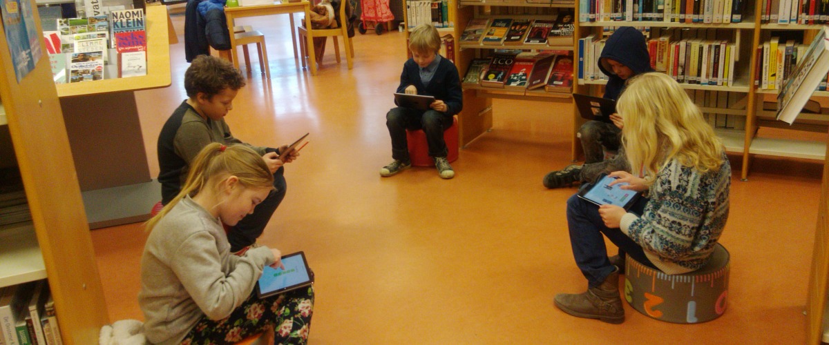 Enkele kinderen testen Bieblo uit in de bib van Mariakerke