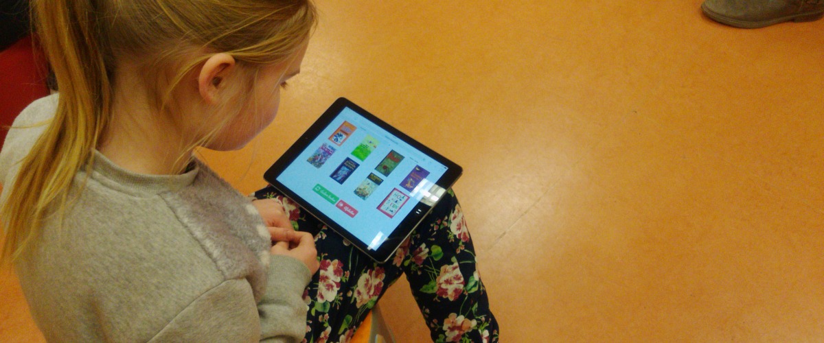 Een kind test Bieblo uit tijdens de gebruikerstesten in de bib van Mariakerke