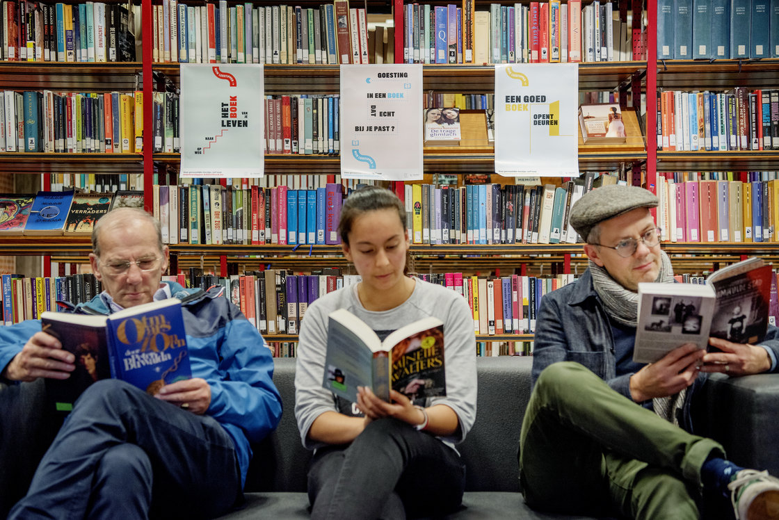 Drie mensen lezen een verschillend boek en zitten onder de affiches van Mijn Leestipper.