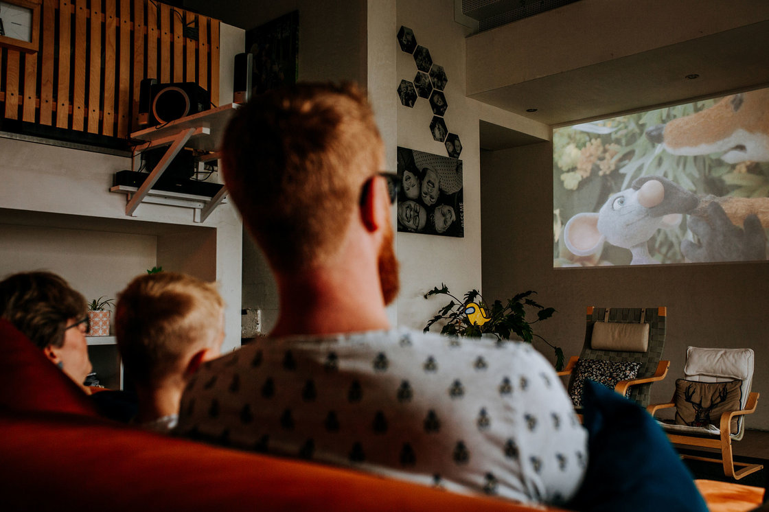 Gezin kijkt naar een film op groot scherm.
