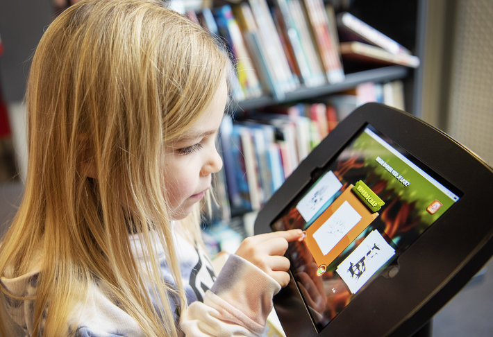 Meisje speelt Bieblo op tablet in de bib.